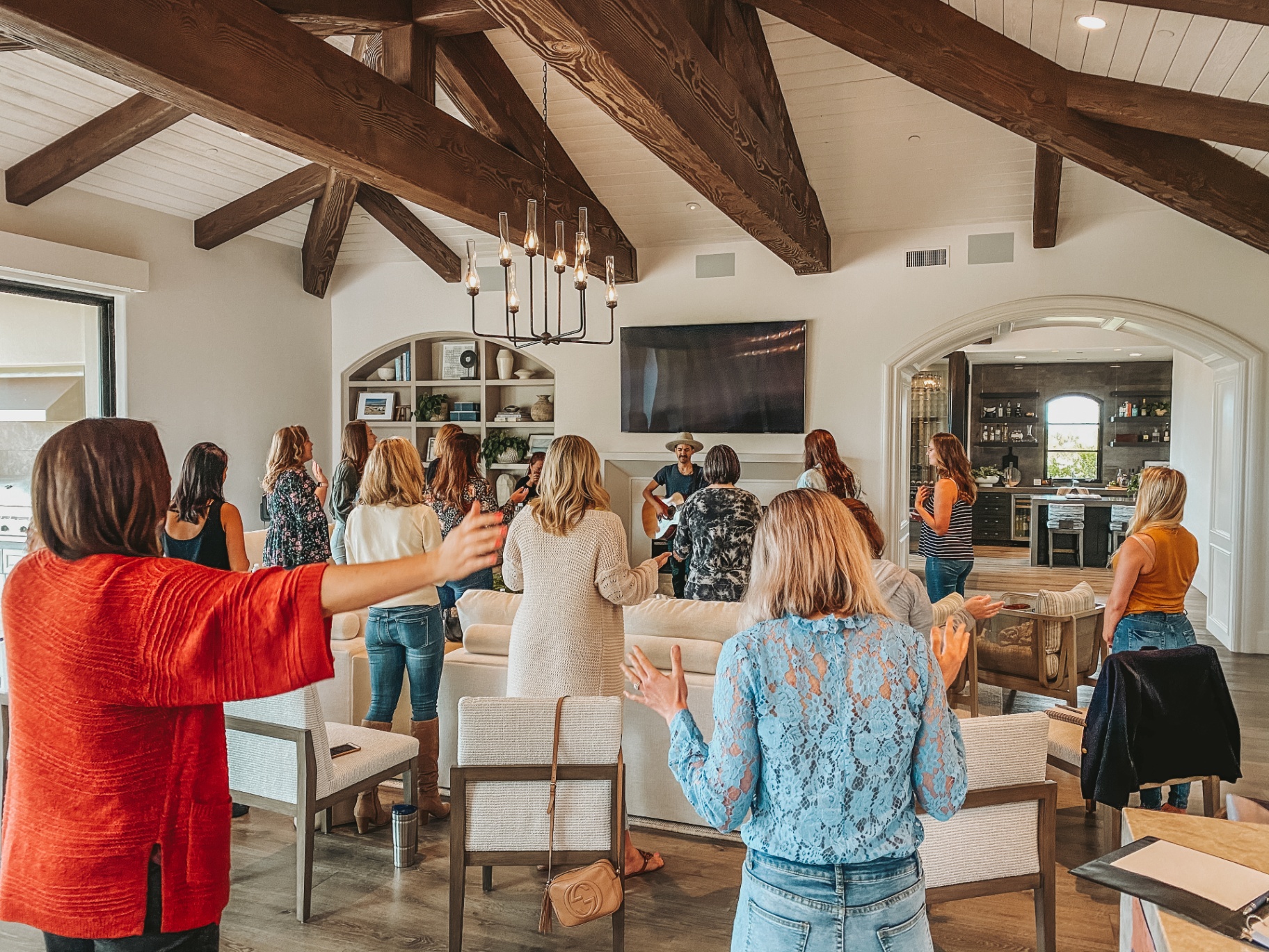 Women worshipping with arms outstretched to live guitar