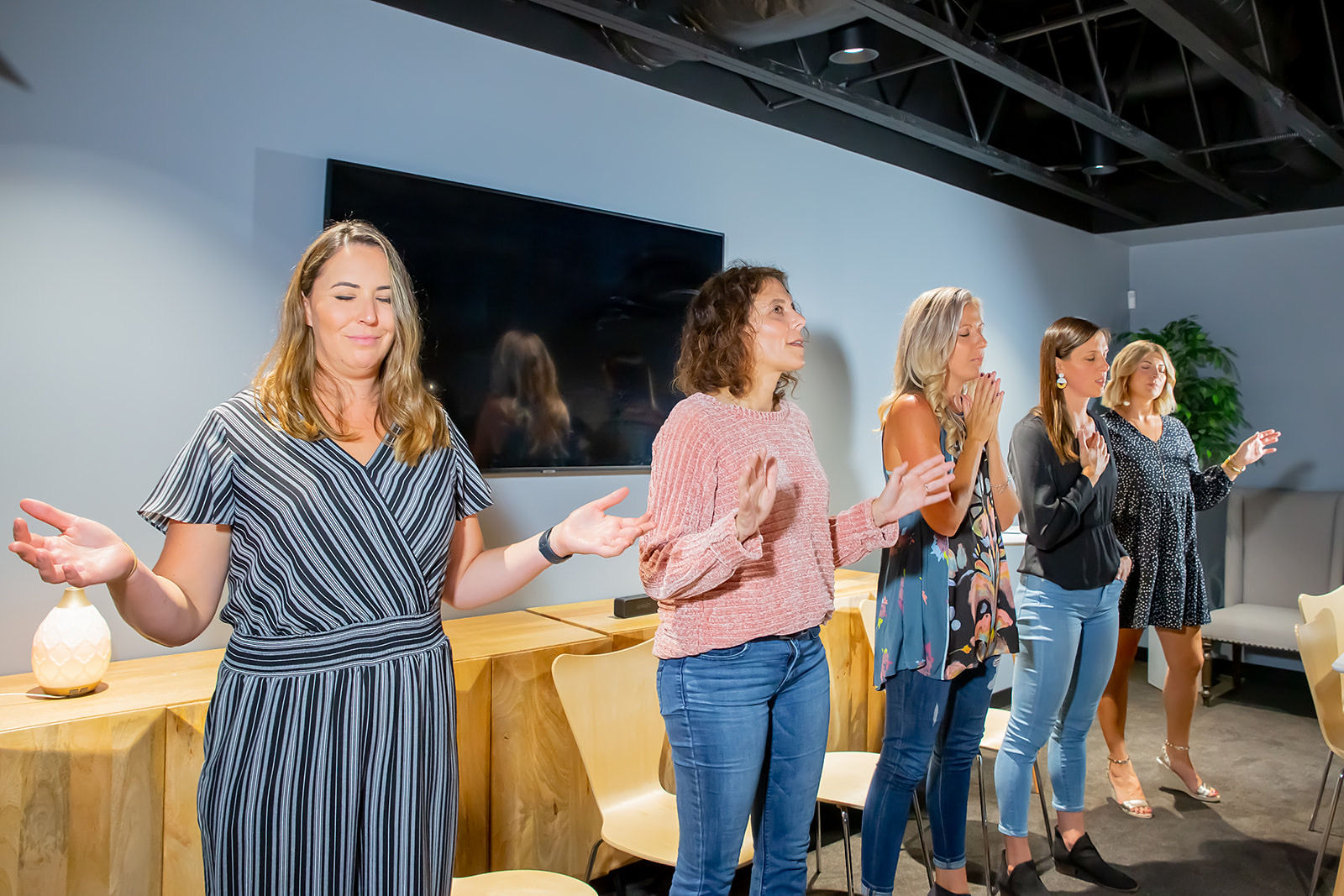 Women praying together in a gathering room